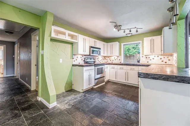 a kitchen with a sink window and cabinets