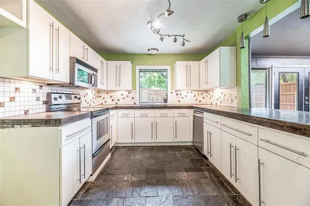 a large white kitchen with a sink and cabinets