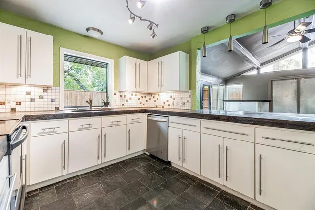 a kitchen with a sink window and cabinets