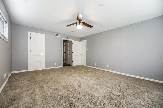 a view of an empty room with a ceiling fan