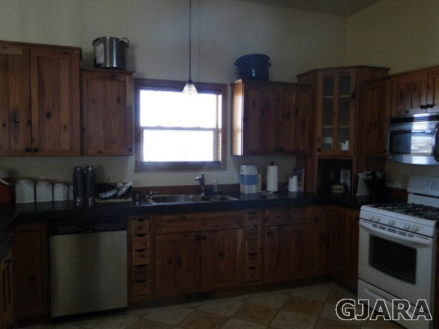 2501 Riata Ranch Road Grand Junction, CO 81505 - Photo 4 of 16 a kitchen with granite countertop wooden cabinets and a stove top oven