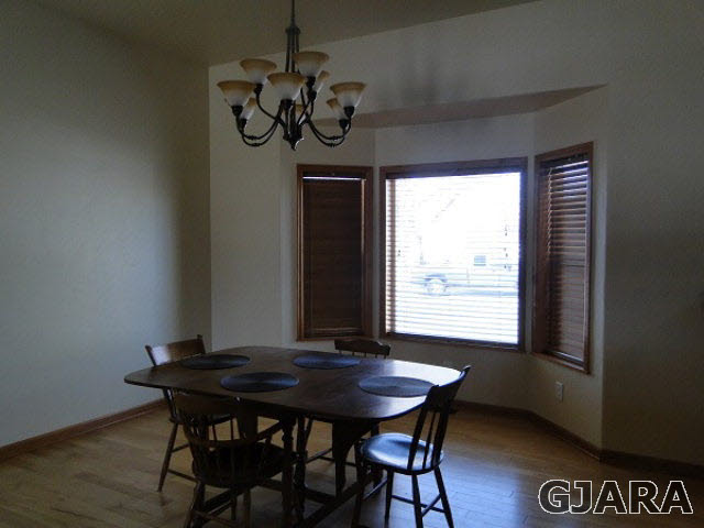 2501 Riata Ranch Road Grand Junction, CO 81505 - Photo 6 of 16 a view of a dining room with furniture window and wooden floor