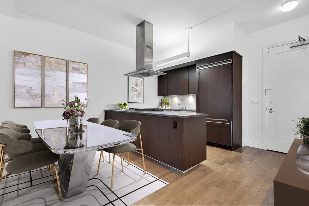 225 5th Avenue, Unit 6R Manhattan, NY 10010 - Photo 2 of 8 a kitchen with stainless steel appliances kitchen island granite countertop a sink refrigerator and cabinets