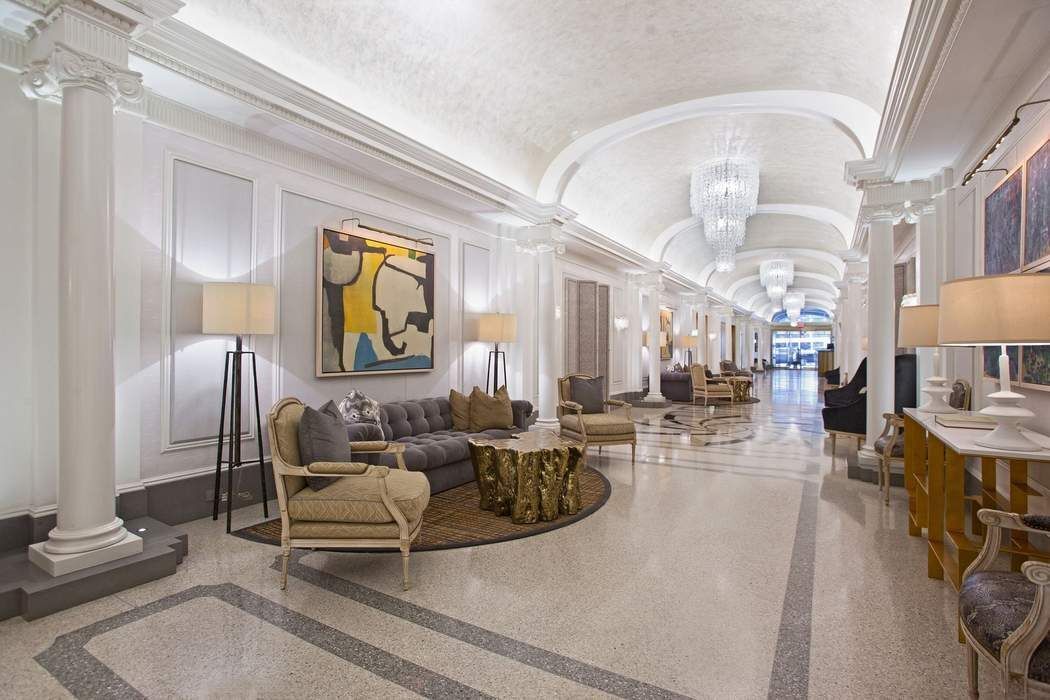 225 5th Avenue, Unit 6R Manhattan, NY 10010 - Photo 6 of 8 a living room with furniture and a chandelier
