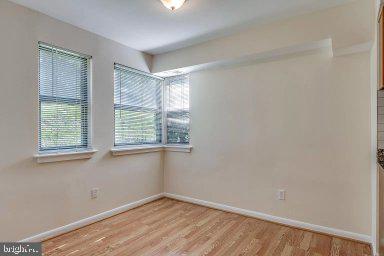 11232 Chestnut Grove Square, Unit 20 Reston, VA 20190 - Photo 16 of 40 an empty room with wooden floor and windows