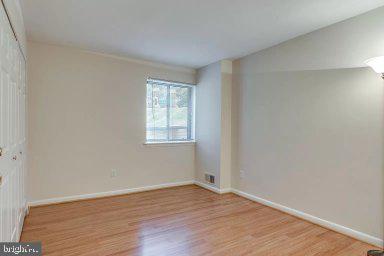 11232 Chestnut Grove Square, Unit 20 Reston, VA 20190 - Photo 21 of 40 an empty room with wooden floor and windows