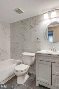 11232 Chestnut Grove Square, Unit 20 Reston, VA 20190 - Photo 24 of 40 a bathroom with a toilet a sink a mirror a bathtub and vanity
