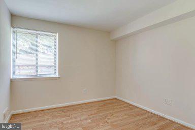 11232 Chestnut Grove Square, Unit 20 Reston, VA 20190 - Photo 25 of 40 a view of an empty room with wooden floor and a window