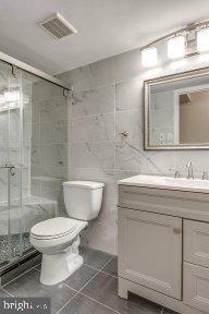 11232 Chestnut Grove Square, Unit 20 Reston, VA 20190 - Photo 30 of 40 a bathroom with a sink a toilet and a mirror