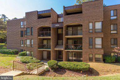 11232 Chestnut Grove Square, Unit 20 Reston, VA 20190 - Photo 3 of 40 a front view of a brick house with a yard