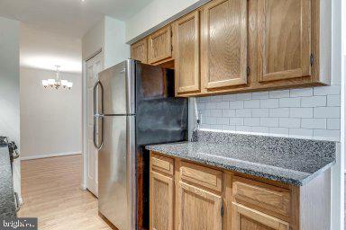 11232 Chestnut Grove Square, Unit 20 Reston, VA 20190 - Photo 9 of 40 a kitchen with granite countertop stainless steel appliances a refrigerator and cabinets