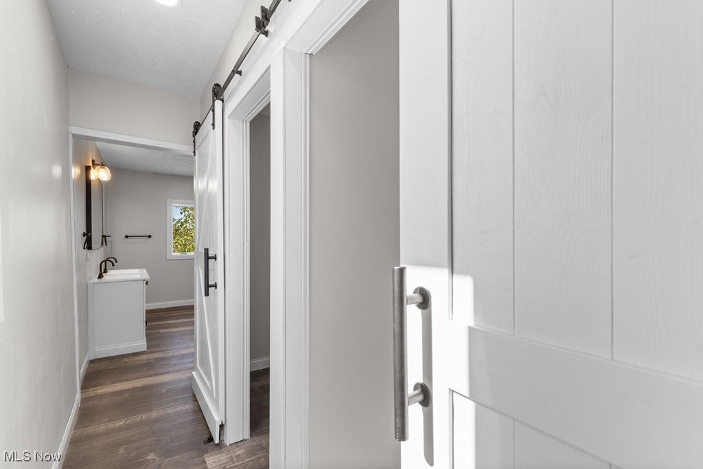 139 Patterson Road Weirton, WV 26062 - Photo 25 of 46 Corridor with a barn door and dark wood-type flooring