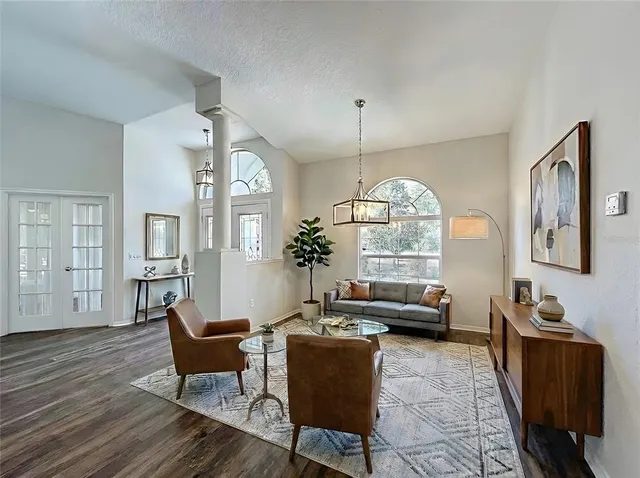a living room with furniture chandelier and a large window