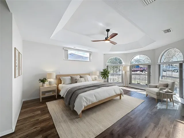 a spacious bedroom with a large bed and a chandelier