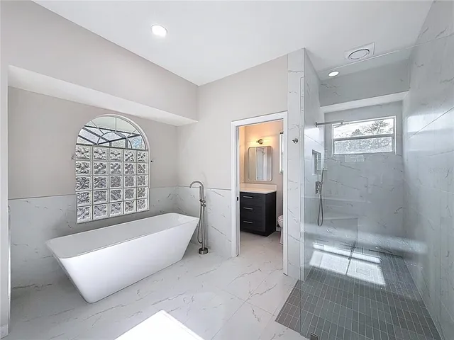 a spacious bathroom with a bathtub and a shower