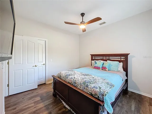 a bedroom with a bed and a ceiling fan