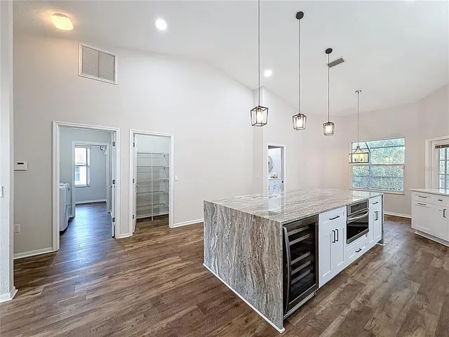a kitchen with stainless steel appliances granite countertop a stove and a wooden floor