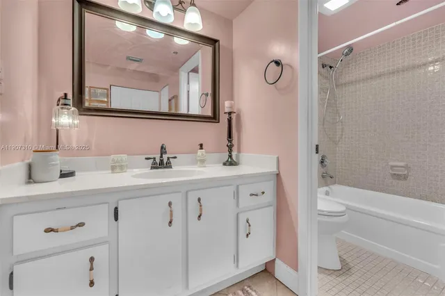 a bathroom with a toilet a sink a mirror a shower and vanity