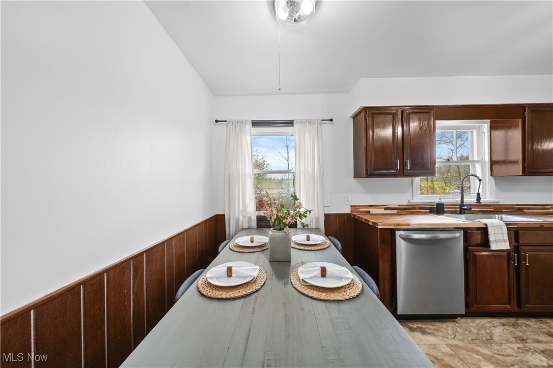 10078 Ellsworth Road Hudson, OH 44236 - Photo 5 of 34 Dining space featuring sink, vaulted ceiling, and wooden walls