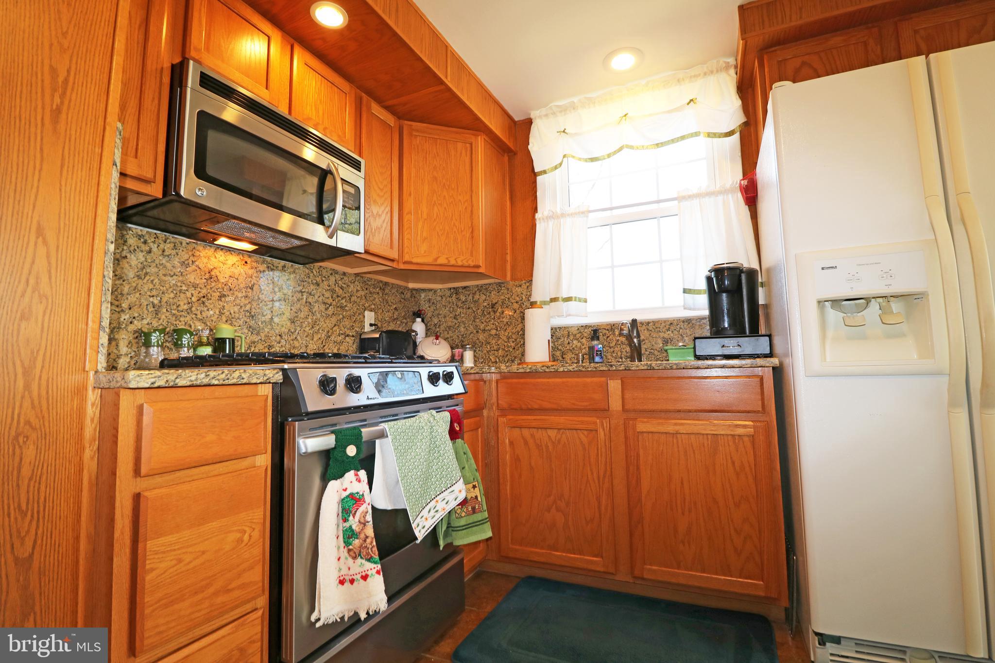 716 Cambridge Road Brookhaven, PA 19015 - Photo 14 of 42 a view of a kitchen with fridge and wooden floor