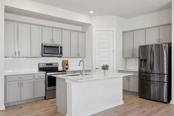 a large kitchen with a lot of counter space stainless steel appliances and a large window
