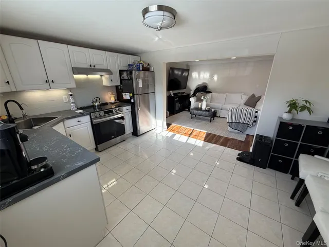 a kitchen with stainless steel appliances a sink a stove top oven a counter space and cabinets