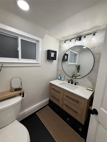 a bathroom with a toilet a sink and mirror
