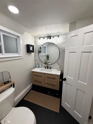 a bathroom with a toilet mirror and vanity