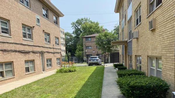a view of a building with garden and bench