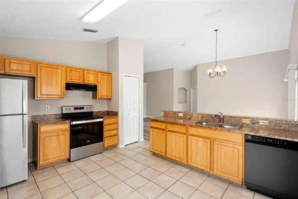 a kitchen with stainless steel appliances granite countertop a sink and stove top oven