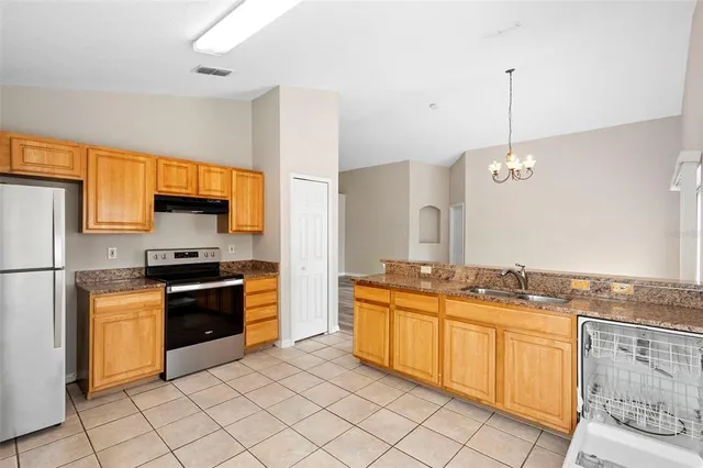 a kitchen with stainless steel appliances granite countertop a stove a sink and a refrigerator