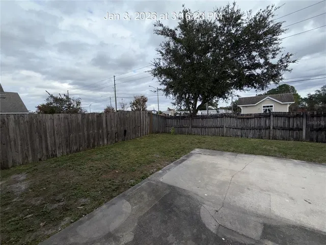 a view of backyard with wooden fence
