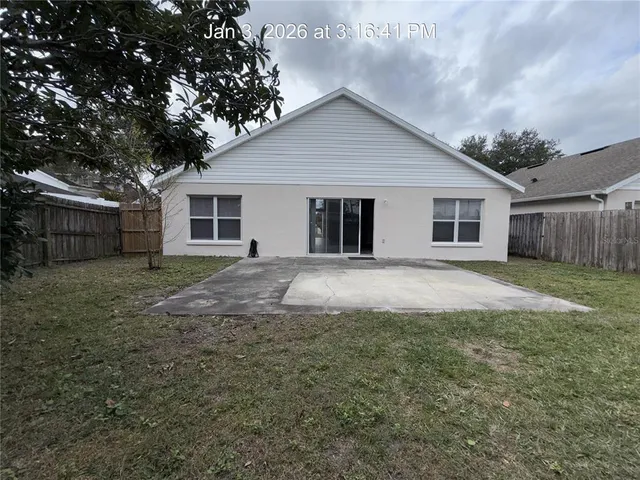 a view of a yard in front of a house with large tree