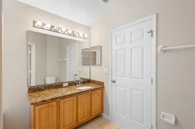 a bathroom with a granite countertop sink and a mirror