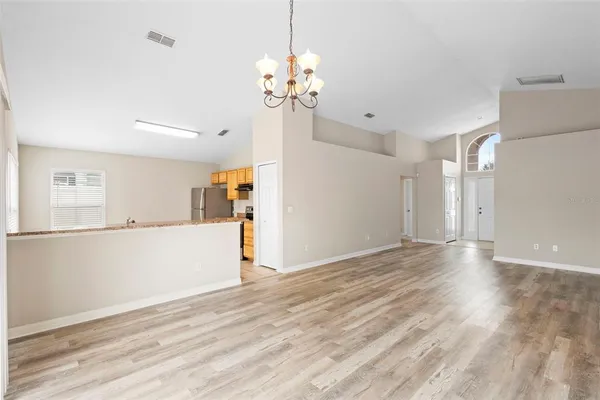 a view of a room with wooden floor and chandelier