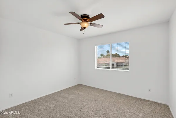 an empty room with a window and a fan
