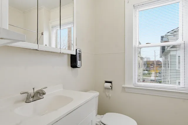 a bathroom with a sink a toilet and a window