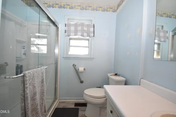 a white toilet sitting next to a bathroom sink and a shower