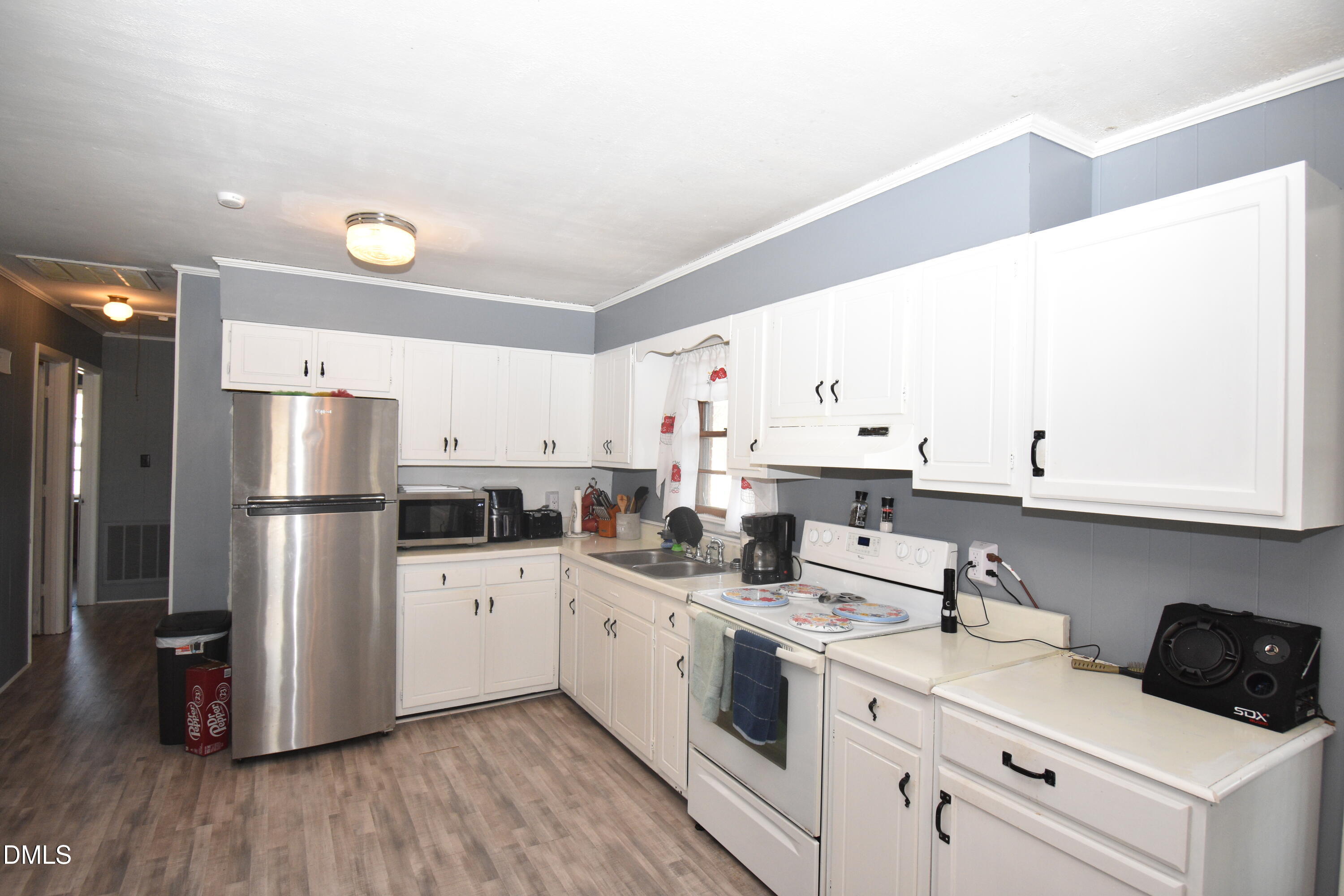 216 Sullivan Road Selma, NC 27576 - Photo 9 of 24 a kitchen with a sink a refrigerator and white cabinets