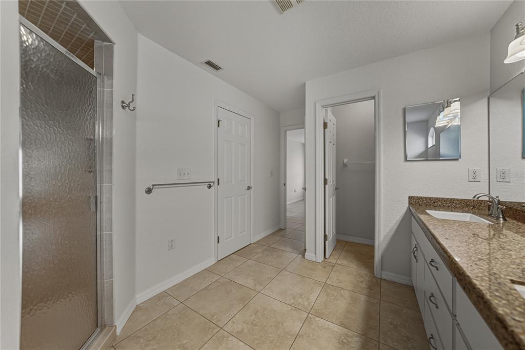 315 Cloverdale Road Winter Haven, FL 33884 - Photo 42 of 65 a spacious bathroom with a granite countertop sink a mirror and a bathtub
