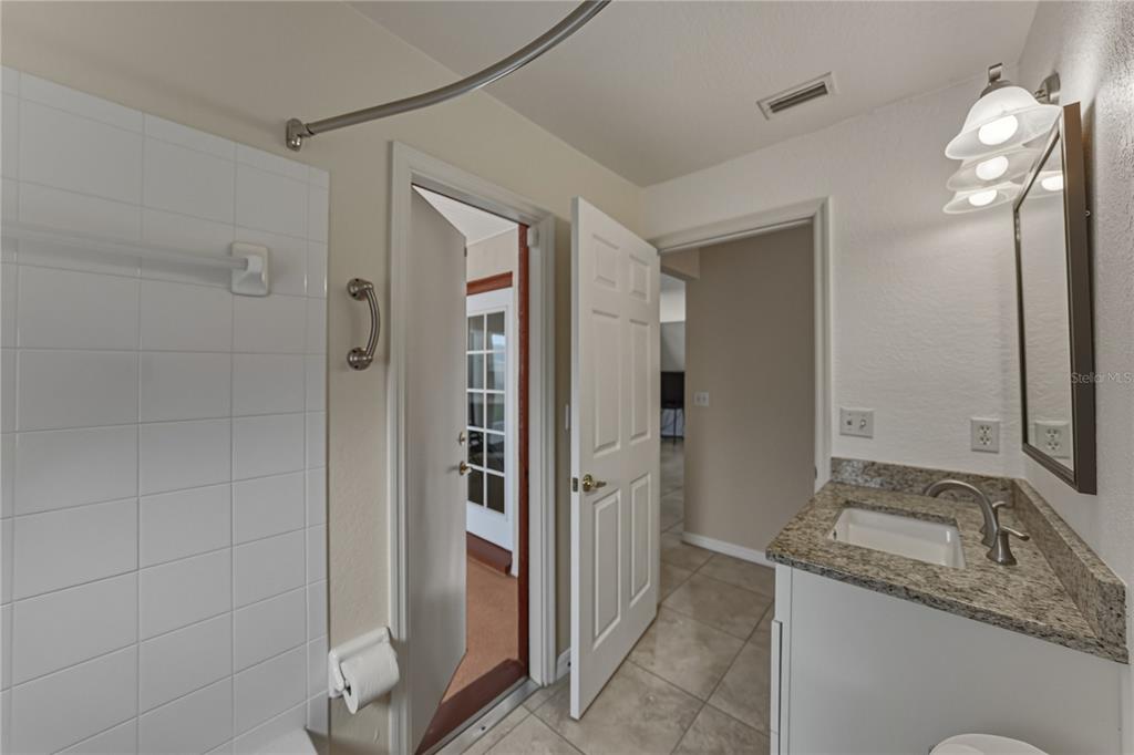 315 Cloverdale Road Winter Haven, FL 33884 - Photo 49 of 65 a bathroom with a granite countertop sink a shower and a mirror