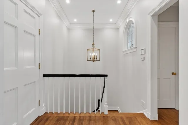 a view of a hallway with wooden floor and staircase