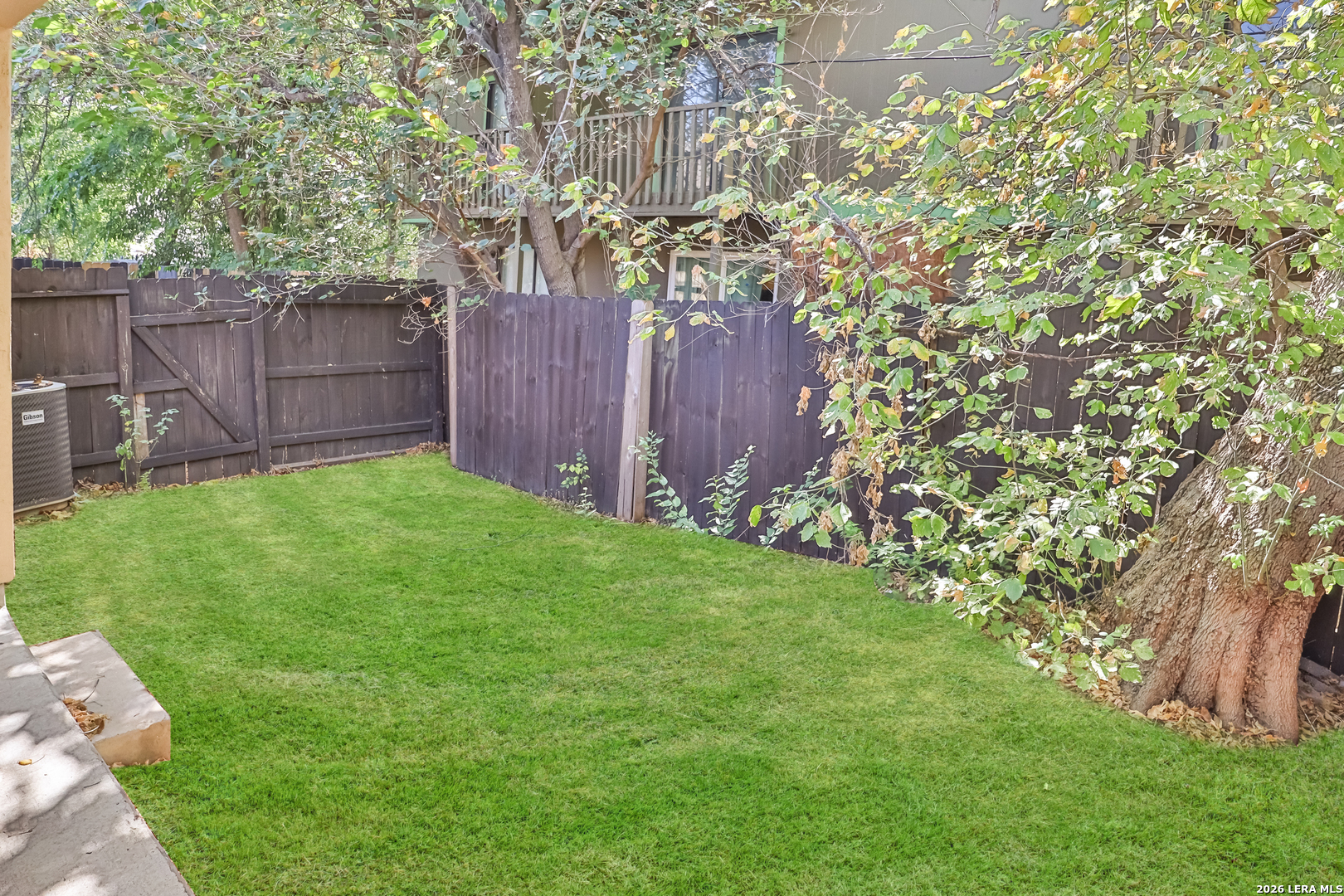 3202 Eisenhauer Road, Unit 402 San Antonio, TX 78209 - Photo 10 of 10 a view of a backyard with large trees and wooden fence