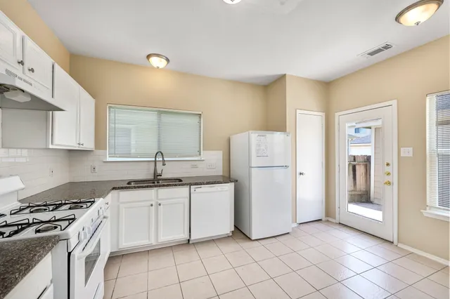 a kitchen with white cabinets and white appliances
