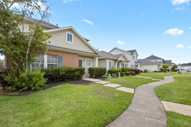 a front view of a house with a yard and potted plants