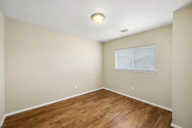 a view of a room with wooden floor and white walls