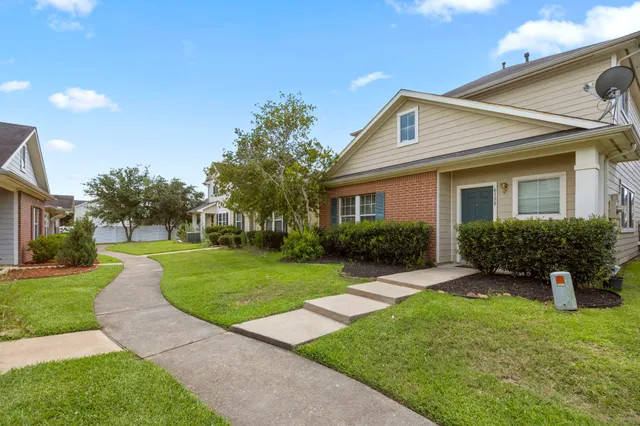 a front view of a house with a yard and potted plants