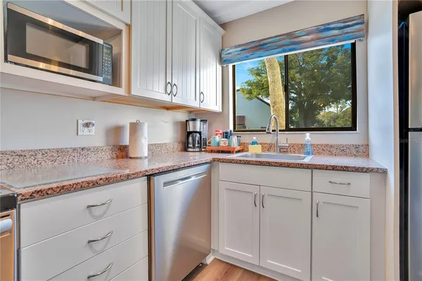 a kitchen with granite countertop cabinets stainless steel appliances and a counter space