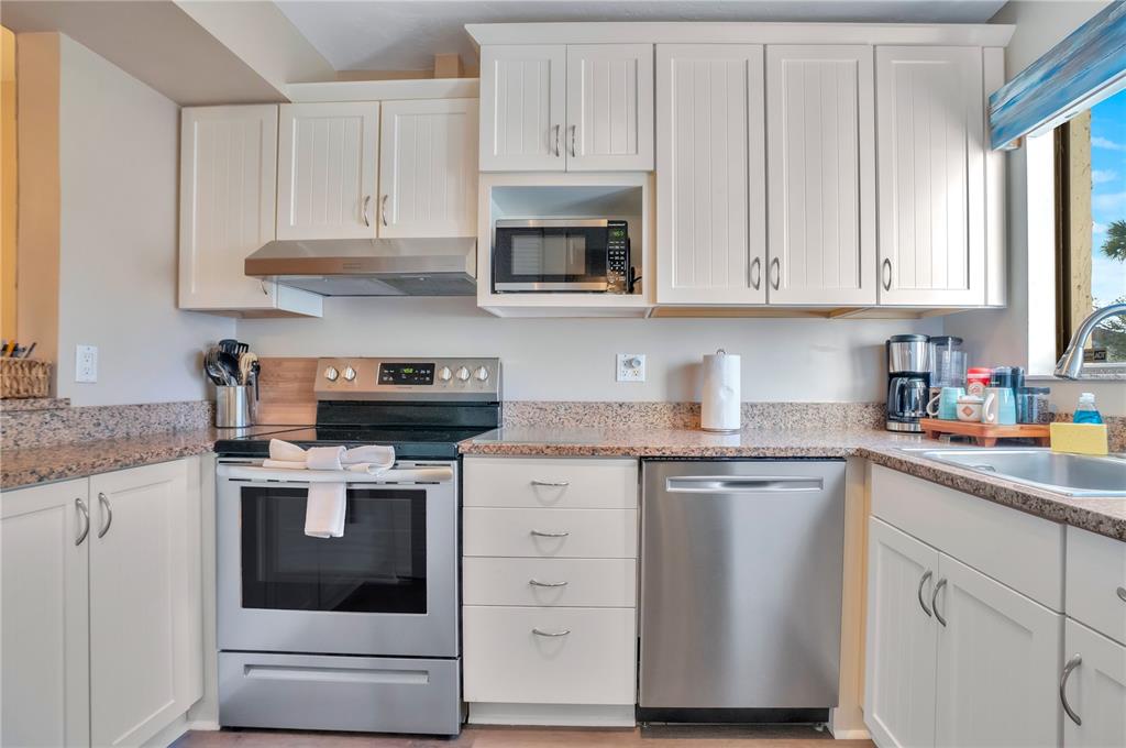 1646 Stickney Point Road, Unit 1646101 Sarasota, FL 34231 - Photo 15 of 67 a kitchen with white cabinets and sink