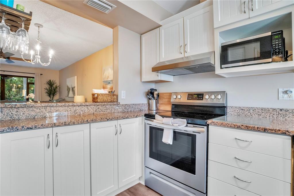 1646 Stickney Point Road, Unit 1646101 Sarasota, FL 34231 - Photo 16 of 67 a kitchen with granite countertop cabinets stainless steel appliances and a counter space